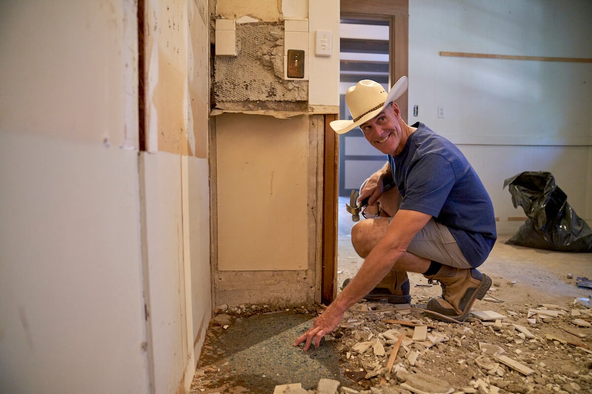 Brett Waterman crouching during a home renovation in an episode of 'Restored' on Magnolia Network