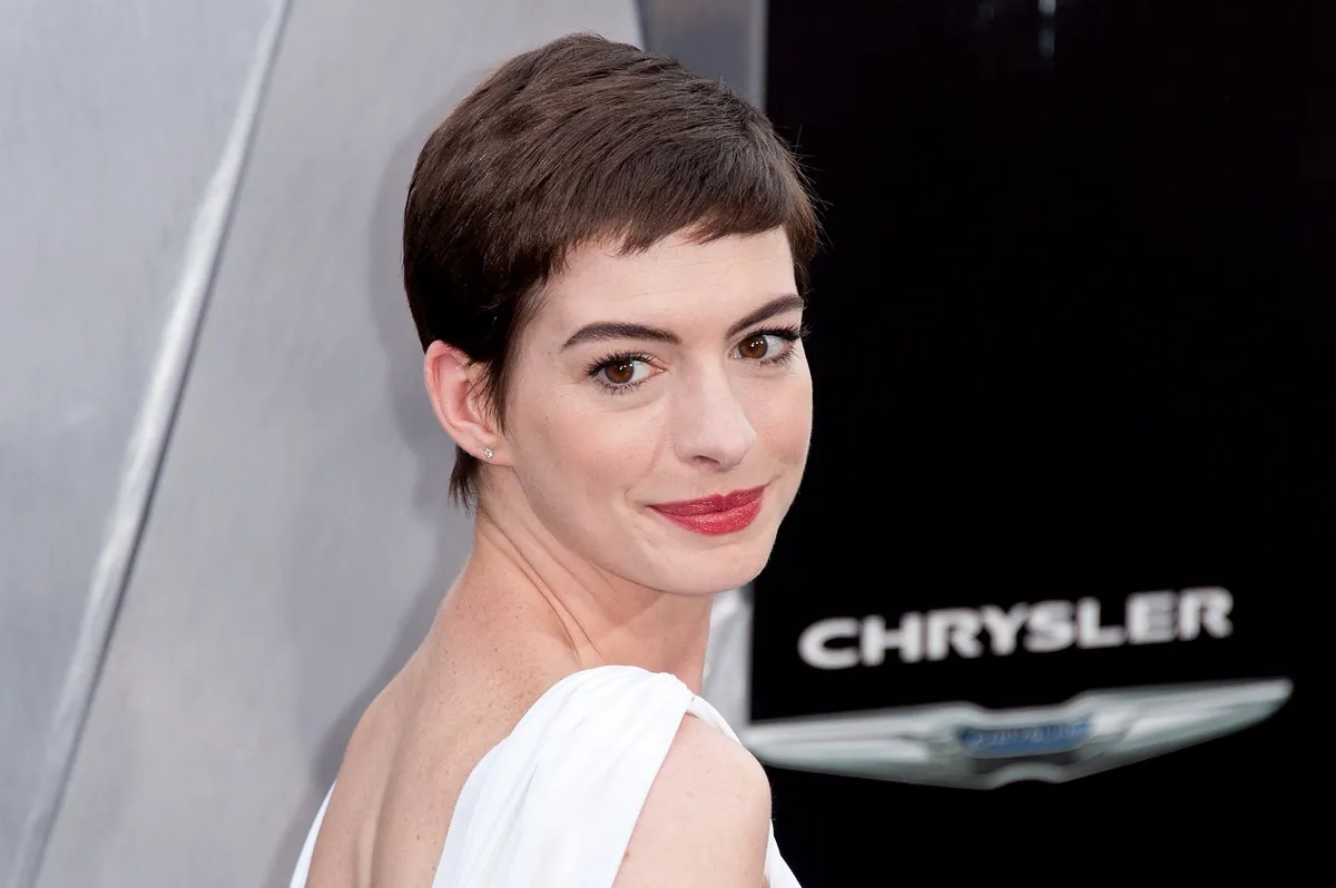 Anne Hathaway posing in a white dress at the Catwoman premiere.