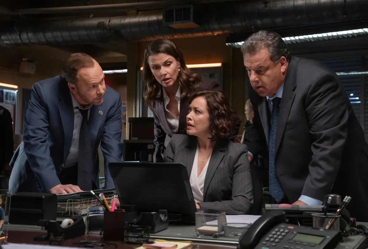 A group of people gathered around a computer screen in the 'Blue Bloods' series finale