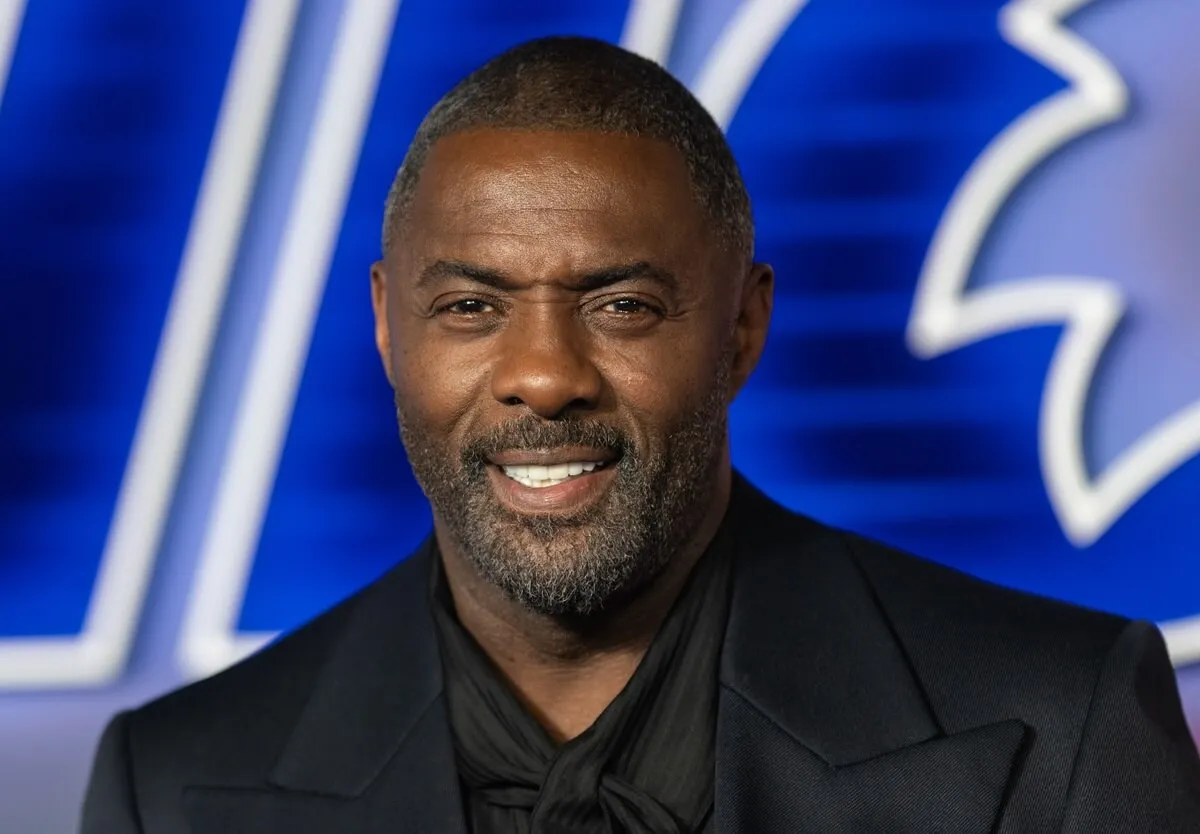 Idris Elba smiling at the premiere of 'Sonic 3' in a black suit.