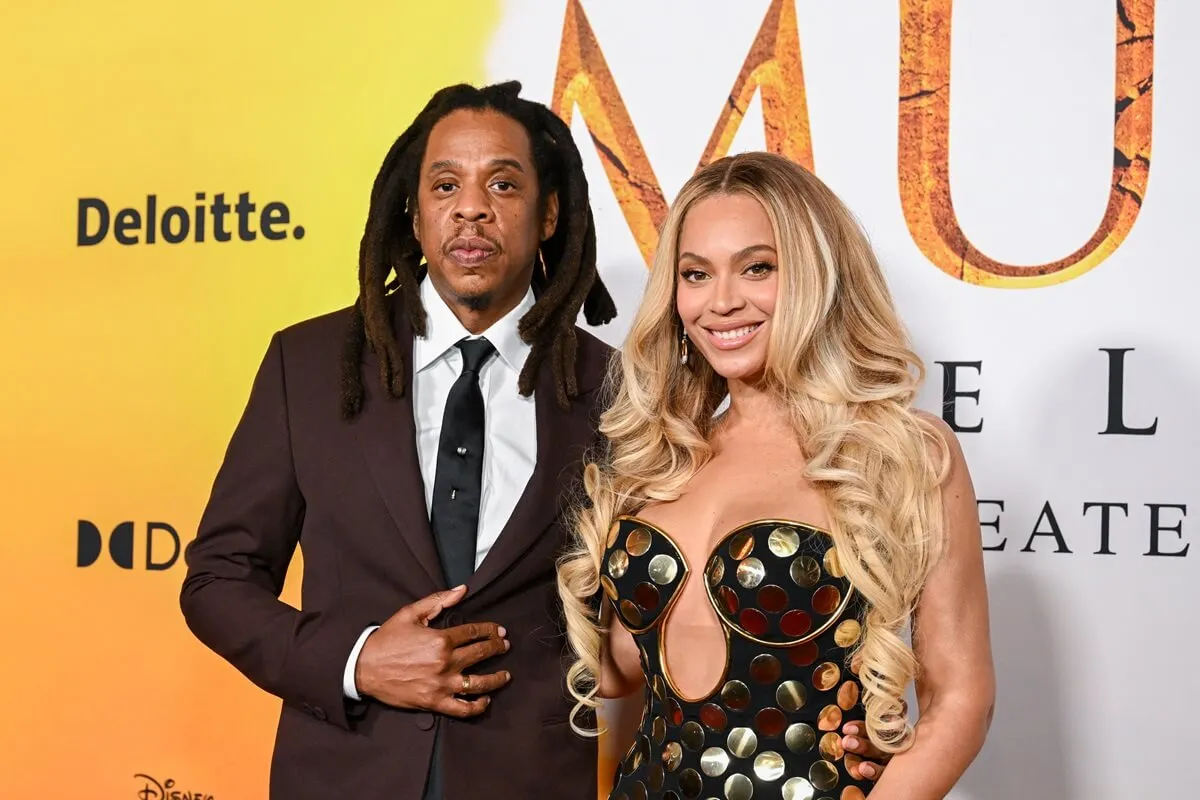 Jay-Z and Beyoncé at the 'Mufasa: The Lion King' premiere in Los Angeles. Jay-Z is wearing a brown suit and Beyoncé is wearing a metallic gold and brown strapless gown.