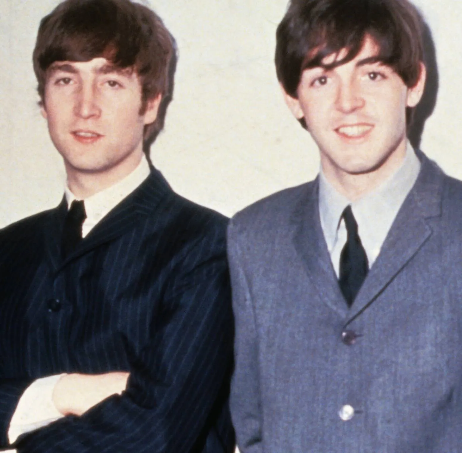 John Lennon and Paul McCartney leaning against a wall