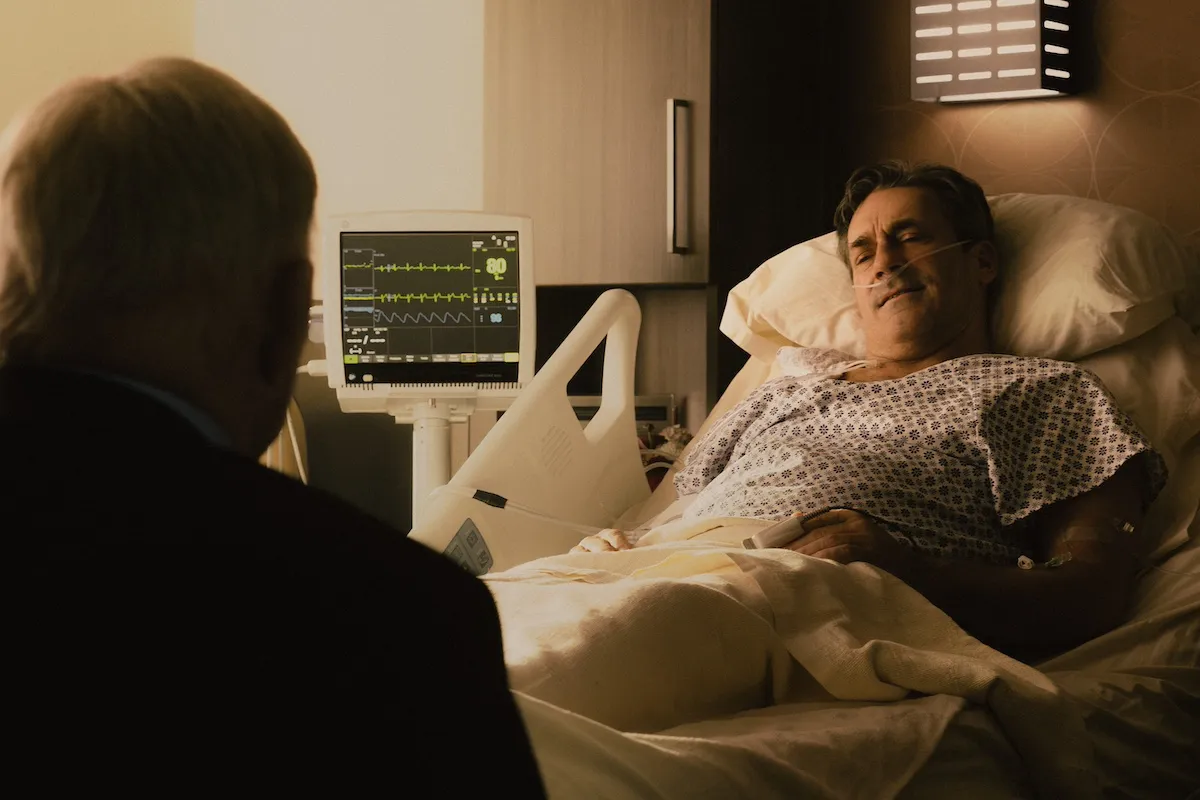 Jon Hamm in a hospital bed with Bill Bob Thornton sitting with his back to the camera in 'Landman'