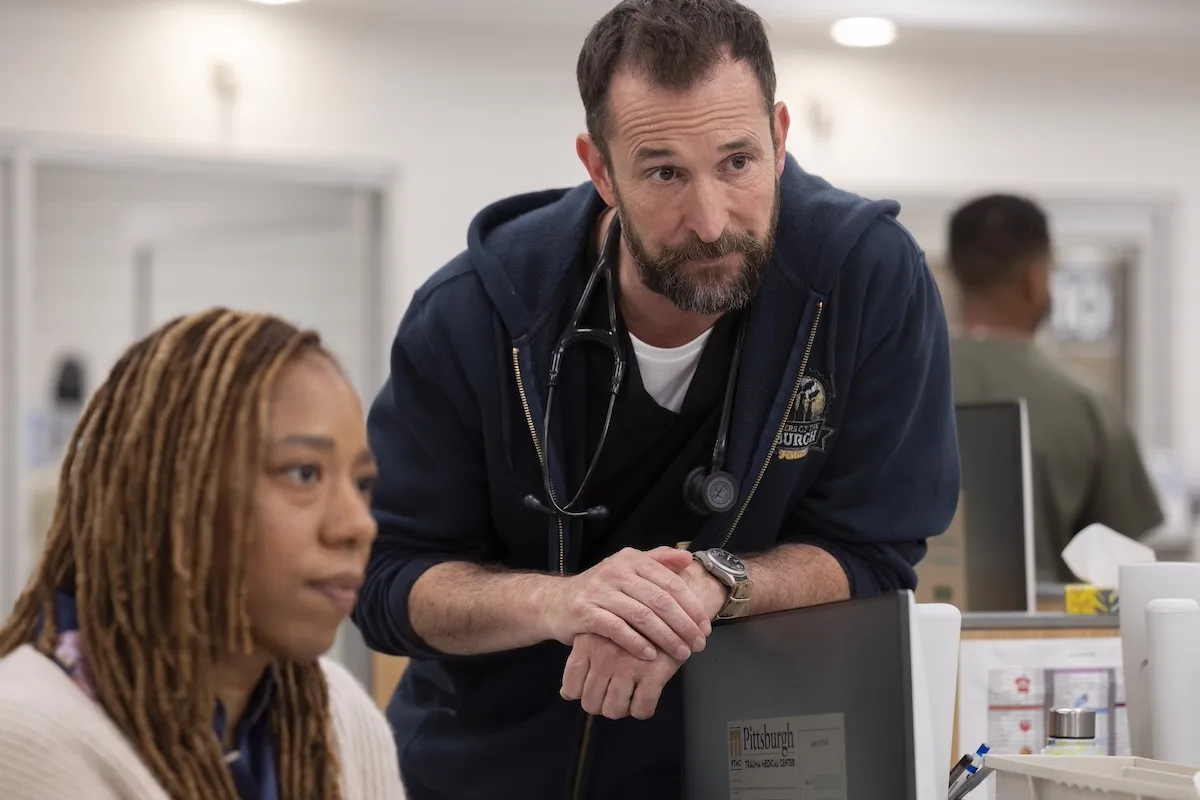 Krystel McNeil and Noah Wyle looking at a computer screen in 'The Pitt'