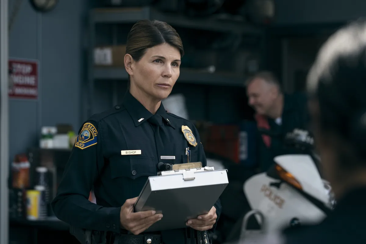 Lori Loughlin dressed in a cop's uniform and holding a clipboard in 'On Call'
