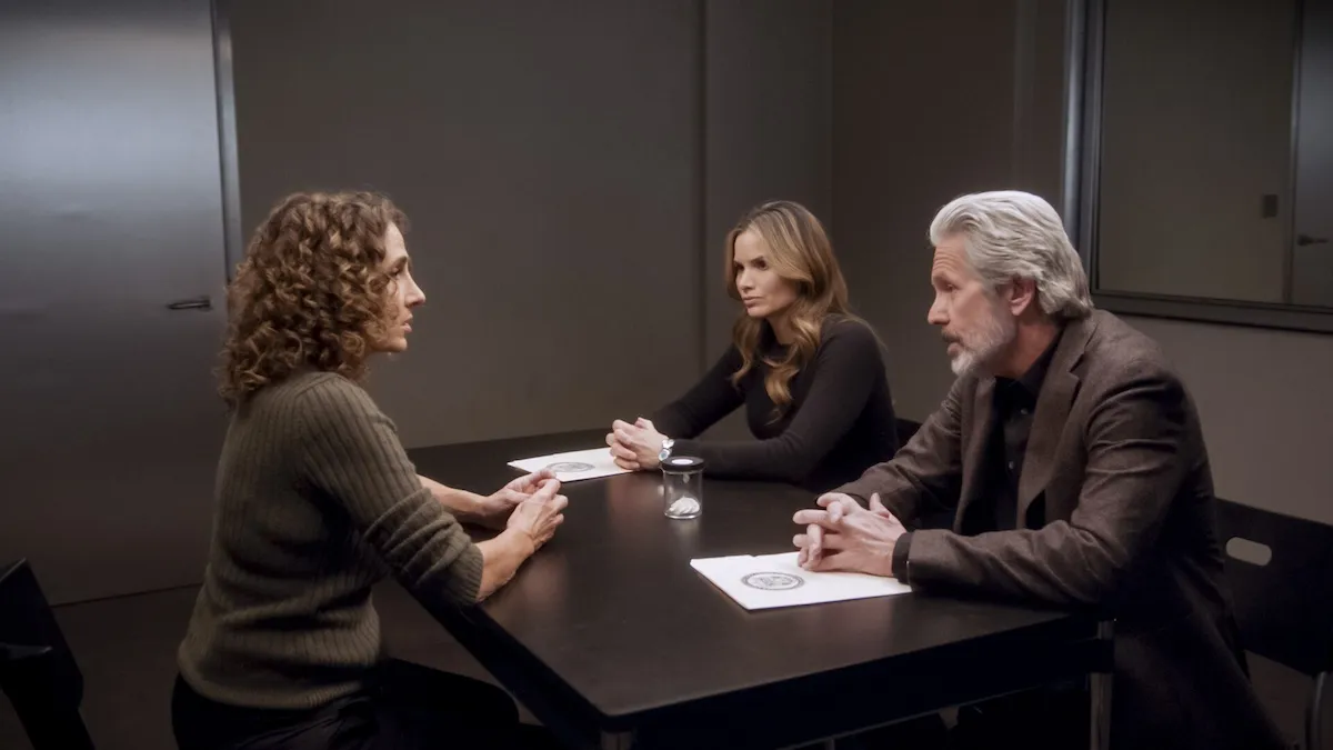 Three people sitting at a table in an interrogation room in 'NCIS' Season 22 Episode 10